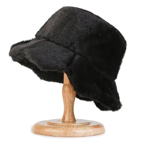 Detailed close-up of a black faux fur bucket hat on a wooden stand with soft plush texture
