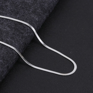 Close-up of a sleek silver flat snake chain necklace with high-gloss polished finish