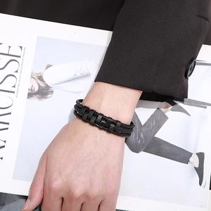 Close-up of men's multi-layer black braided leather bracelet with stylish alloy clasp