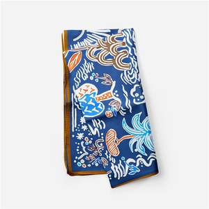 Detail showing tropical palm leaf pattern and brown hem on dark blue silk scarf