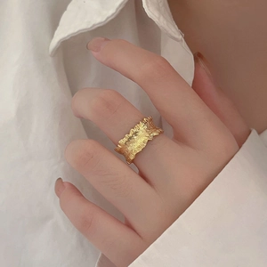 Irregular textured gold 925 silver ring with French wavy design on female hand