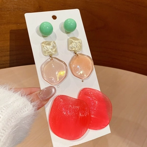 Close-up of resin earring set featuring green beads and pink and red irregular discs