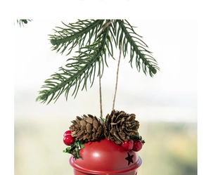 Detail of red Christmas bell with natural pine cones and red berries on hemp rope