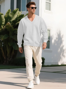Detail of white V-neck cable knit sweater for men with intricate texture in outdoor setting