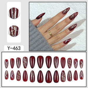 Deep burgundy almond shaped press-on nails with 3D gold accents and marble design