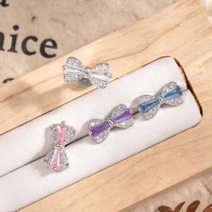 Titanium steel bow stud earrings with colorful zircon stones in a wooden display box