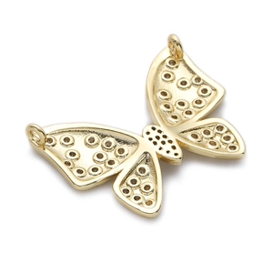 Vue macro d'un pendentif papillon doré aux ailes ajourées pour création de bijoux