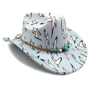 Detail eines hellblauen Cowboyhuts mit Möwendruck und Lederband mit Türkis-Perlen