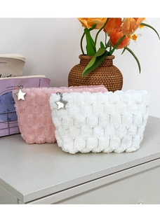 Detail of pink and white plush checkered makeup bags with star-shaped silver zippers