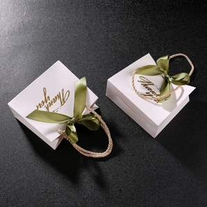 Elegant white paper wedding gift bag with gold Thank You text and dark green ribbon