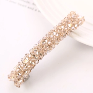 Detail of beaded hair clip with champagne gold crystals on a silver spring base