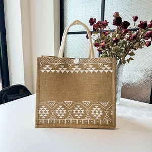 Detail of jute tote bag with white ethnic geometric pattern and woven rope handles