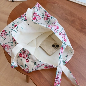 Detail of canvas tote bag interior showing pink tulip print and functional phone pocket