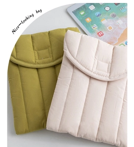 Detail view of olive green and pink quilted laptop sleeves with soft padded texture