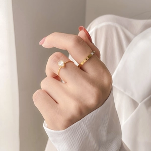 Detailed close-up of gold stacking rings featuring a pear-cut zircon and textured band