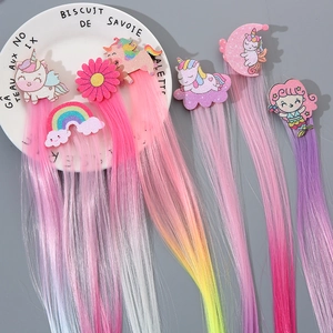 Detail of colorful rainbow hair extensions with glitter unicorn and bow clips for girls