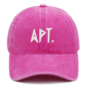 Detailed view of pink washed cotton baseball cap with white APT embroidery and twill texture