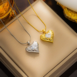 Detailansicht von herzförmigen Zirkonia-Halsketten in Gold und Silber in einer Schmuckbox