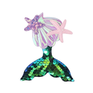Detail of colorful mermaid hair clip with glitter sequin tail and purple seashell