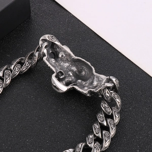 Vue macro d'un bracelet punk argenté avec motifs floraux en relief et maillons de crâne