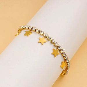 Detail of a gold chain bracelet with star charms and sparkling zircon pave accents
