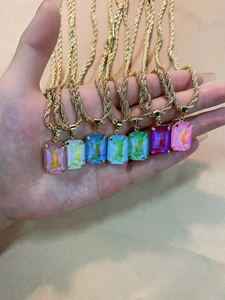 Detailed view of colorful rectangular crystal pendants with golden twisted chain necklaces