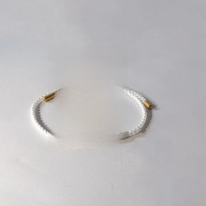 Detail of woven bracelet with gold bar engraved Just Breathe and inspirational card