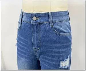 Detail van blauwe denim jeans met hoge taille, metalen knoop en trendy slijtageplekken