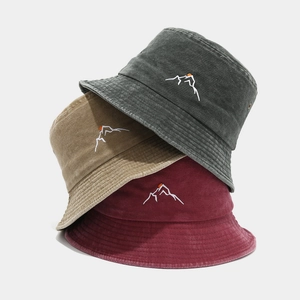 Detail of washed cotton bucket hats with mountain embroidery in grey, khaki and burgundy