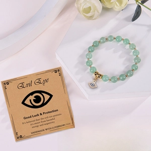 8mm Green Aventurine beaded bracelet with Evil Eye charm on white marble base