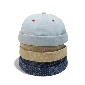 Three paisley docker hats in light blue, khaki, and navy blue stacked on white background