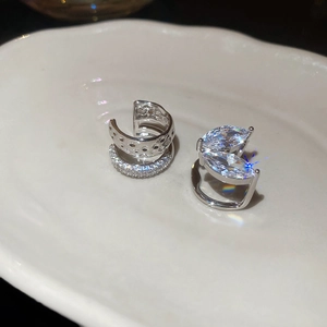 Vue détaillée de boucles d'oreilles en argent et zircons sur un plateau en céramique