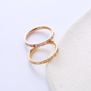 Minimalist titanium steel rings with gold plating and cubic zirconia inlay on white ceramic