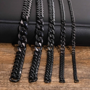 Detail shot of five widths of black Cuban link chains on a luxury textured base