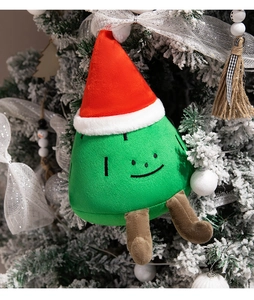 Cute plush Christmas tree hanging ornament with a red hat on a snow-covered tree