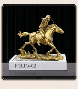Detail of a golden European vintage resin horse rider statue on decorative books