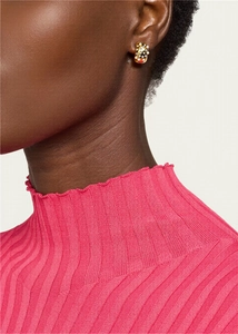 Close-up of model wearing gold stud earrings with white pearls and colorful accents