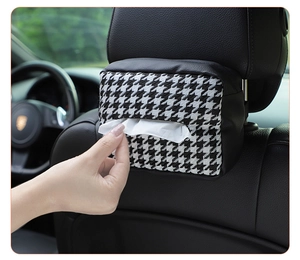 Close-up of houndstooth tissue box with leather detail hanging on car seat headrest