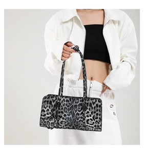 Leopard print baguette bag shown on a model with heart-shaped charm and twin slim handles