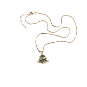 Macro detail of gold-plated Christmas tree pendant with green enamel and crystal accents