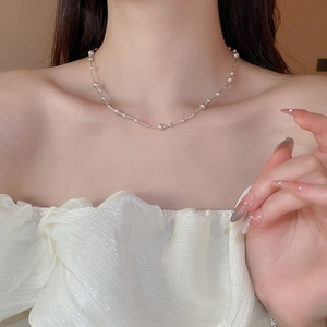 Macro detail of elegant pearl choker necklace with intricate twisted silver chain texture