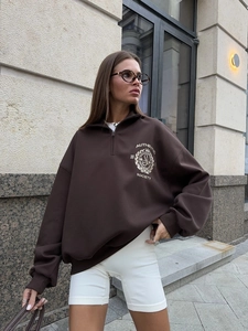 Detail of dark brown vintage sweatshirt featuring a half-zip collar and small chest print