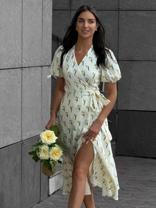 Detail of white cotton wrap dress featuring yellow tulip prints and puffed short sleeves