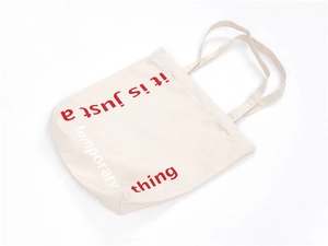 Detail of the high-capacity canvas tote bag featuring artistic red and white printed text