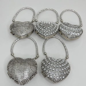 Top view of five silver heart-shaped evening bags with various rhinestone textures