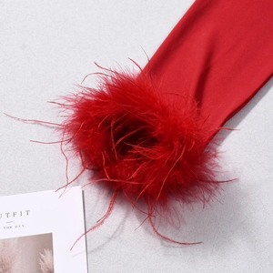 Detailed view of red knitted fabric featuring elegant feather trim and soft texture