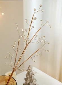 Close-up of golden decorative branches with clear beads for Christmas tree arrangements