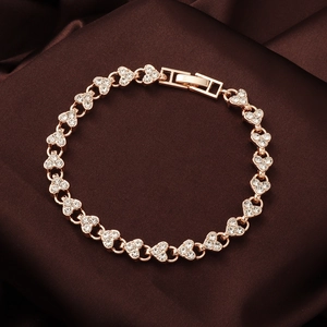 Gros plan du bracelet à maillons cœurs en or rose avec cristaux sur satin marron