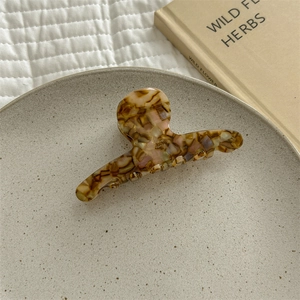 French gradient acetate hair claw clip in amber tortoiseshell on a ceramic plate