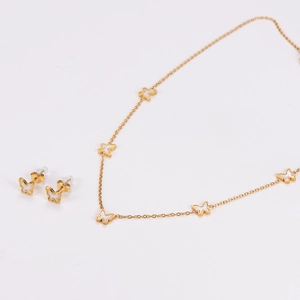 Detailed close-up of golden butterfly necklace and stud earrings set on a white background